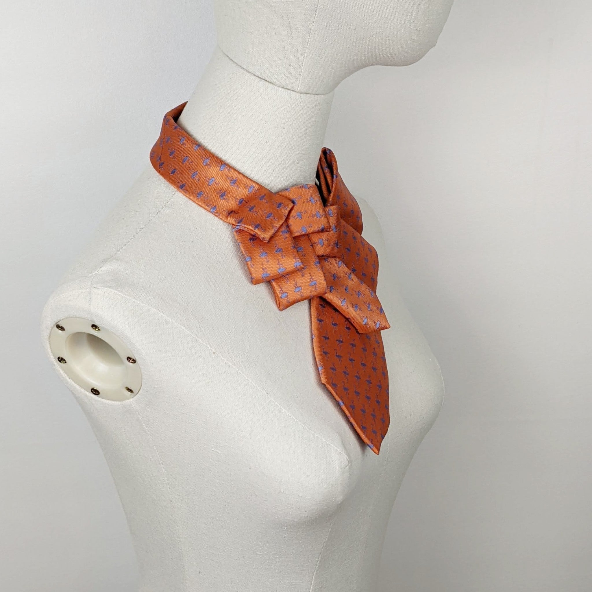 Scarf In Orange With A Blue Flamingo Print.