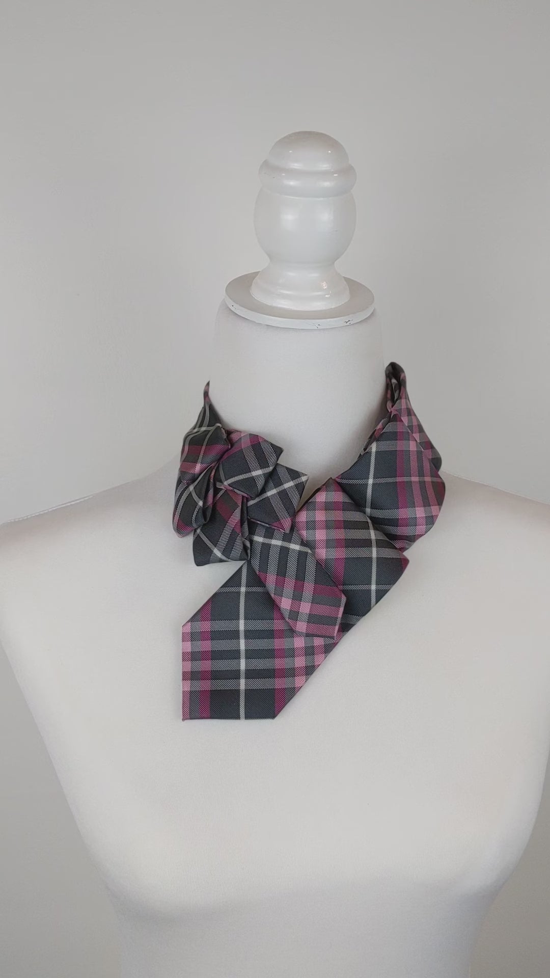 Ascot Scarf In A Grey And Pink Plaid Print.
